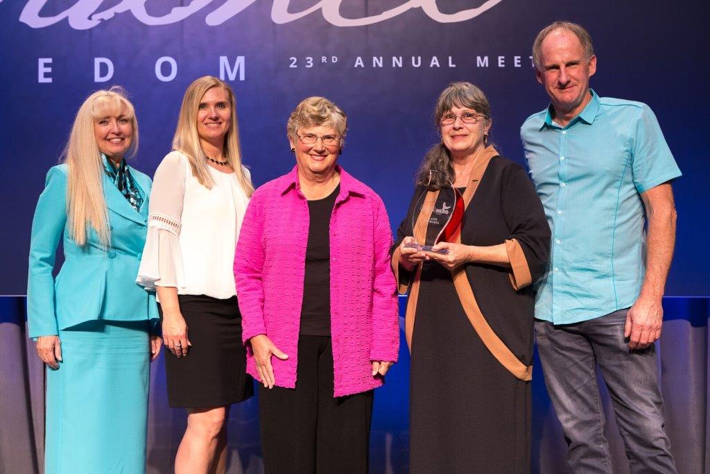 Helen Krieble standing with past Unsung Hero Award winners